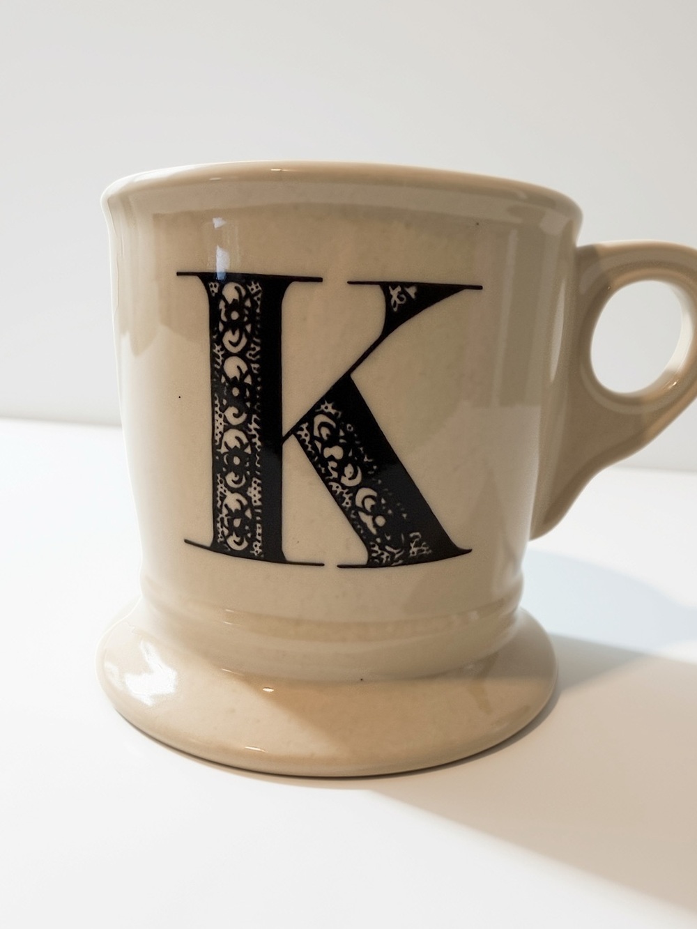 Beige Ceramic Mug with Decorative Black 'K' Monogram